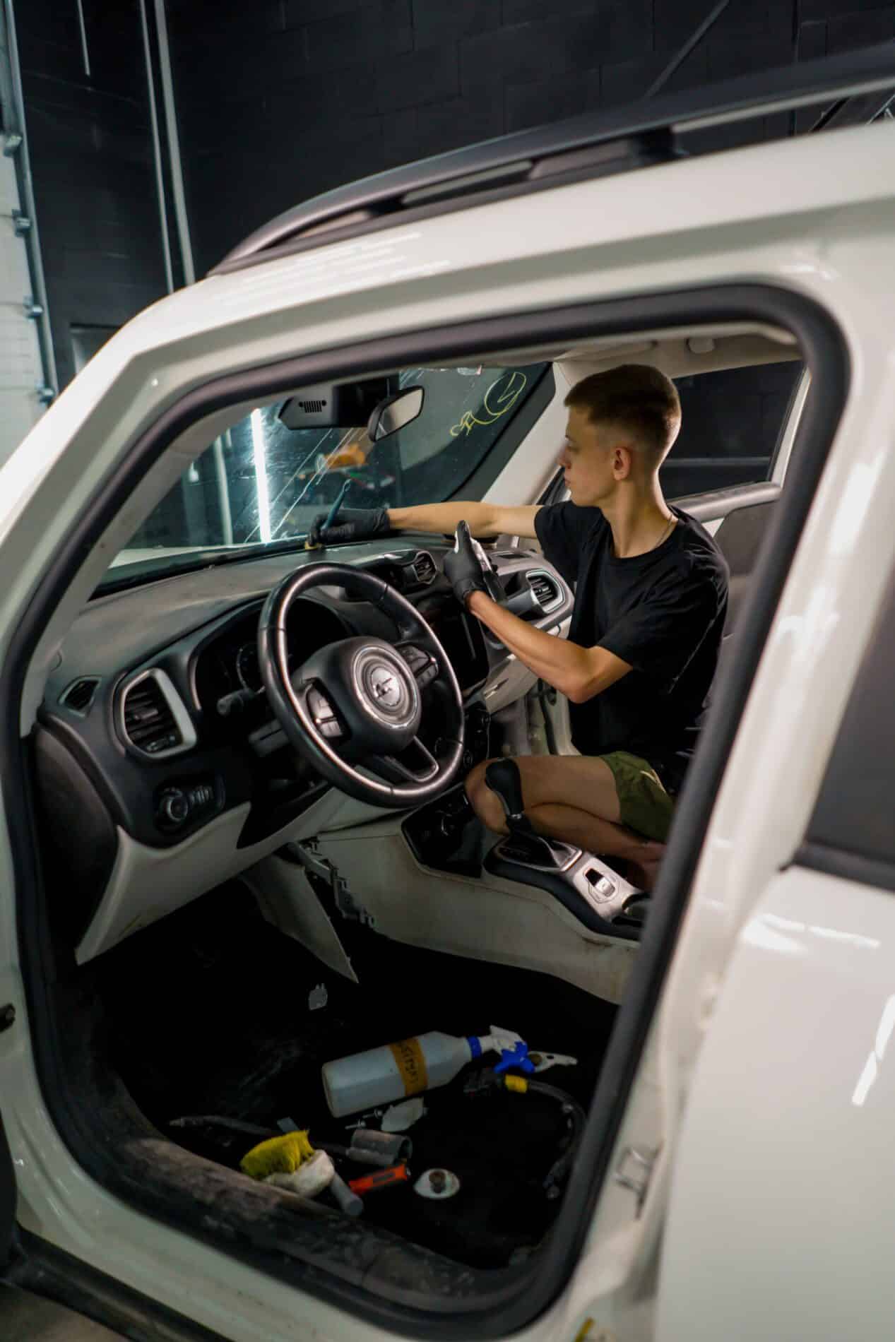 A close-up of a car wash worker using a brush and car chemicals to clean the dashboard of a luxury car during the detailing process close up of a car wash worker using a spray gun an 2024 12 01 05 52 22 utc scaled